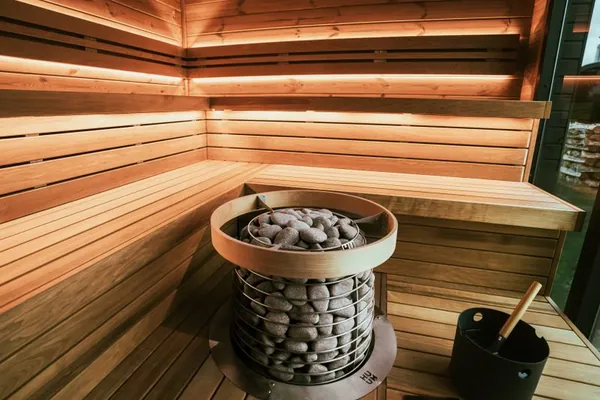 Sauna interior with stone heater and wooden benches