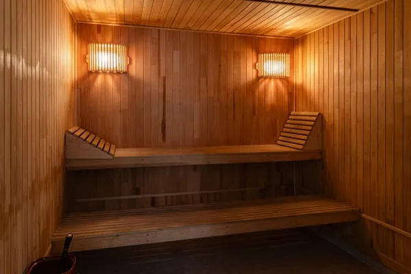 Warm wooden sauna interior with benches and wall lamps