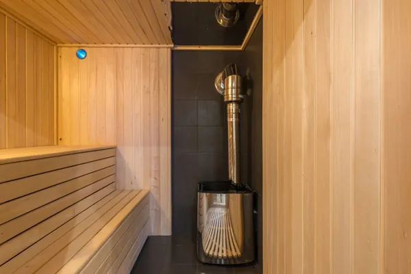 Modern home sauna with sleek metal heater