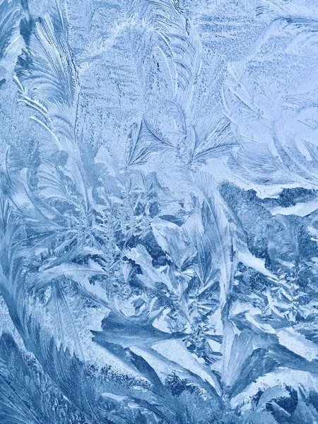 Frost crystals spreading across a windowpane