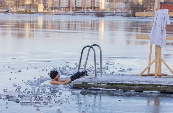 Man swimming in an ice hole during a cold plunge